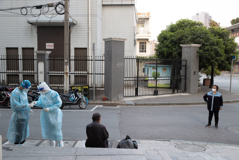 ↑4月11日,广福居委会工作人员为一位路过的流浪人员做抗原检测。