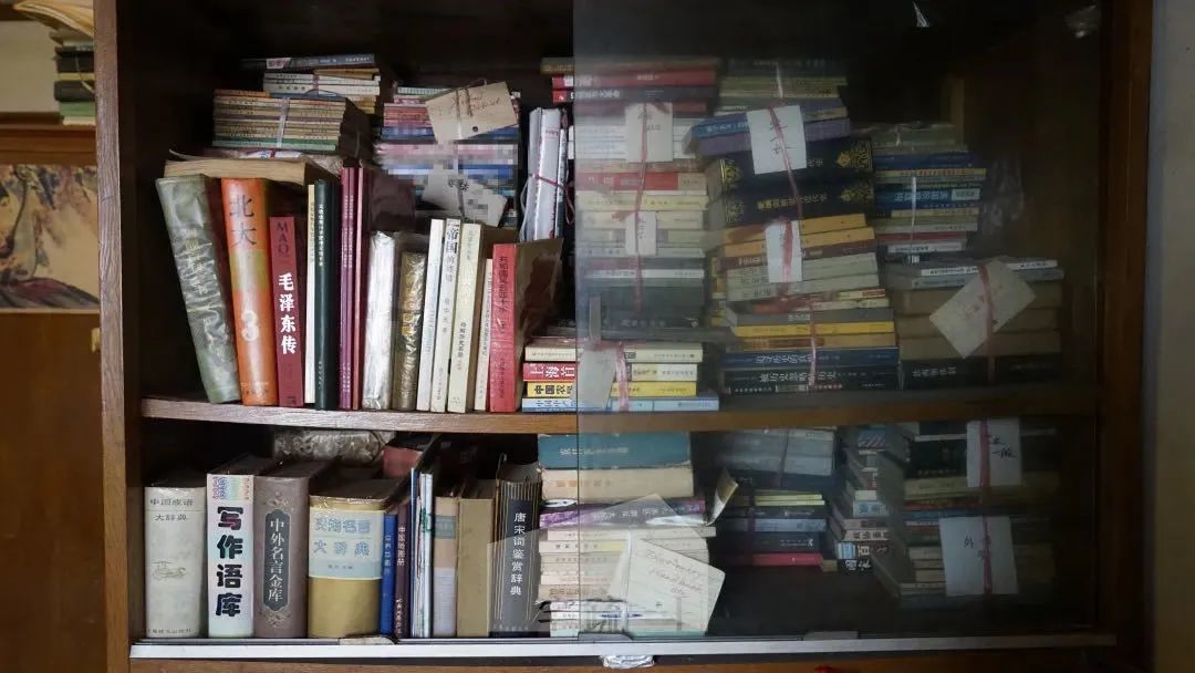 漆畹生的书架，里面挤满了书籍，夹杂着信件。受访者供图