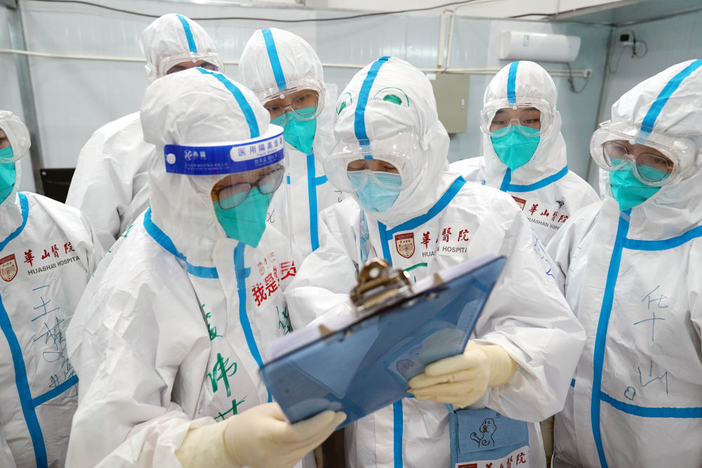 4月25日，上海临港方舱医院的医护人员在交接班时交流感染者的情况。新华社记者 杨有宗 摄