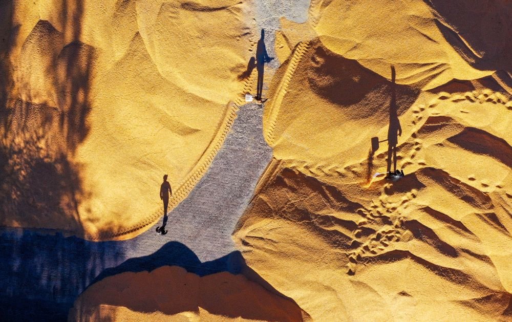 在内蒙古通辽市奈曼旗新镇舍布日图嘎查，工人在收粮站晾晒玉米（2022年10月18日摄，无人机照片）。新华社记者 连振 摄