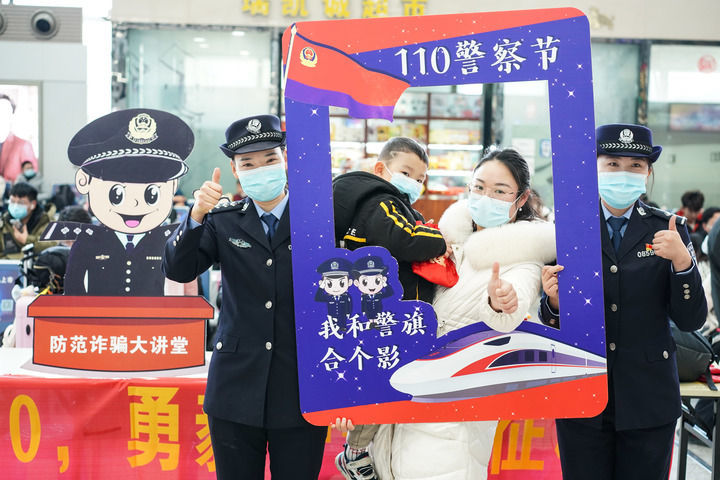 南京铁路公安处联合南京市公安局公交治安分局在南京火车站举行迎接“中国人民警察节”活动，民警和旅客在活动上合影（2022年1月7日摄）。新华社记者 季春鹏 摄