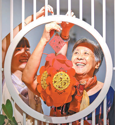 福建福州鼓楼区安泰街道，老人和社区工作者一起悬挂花灯。