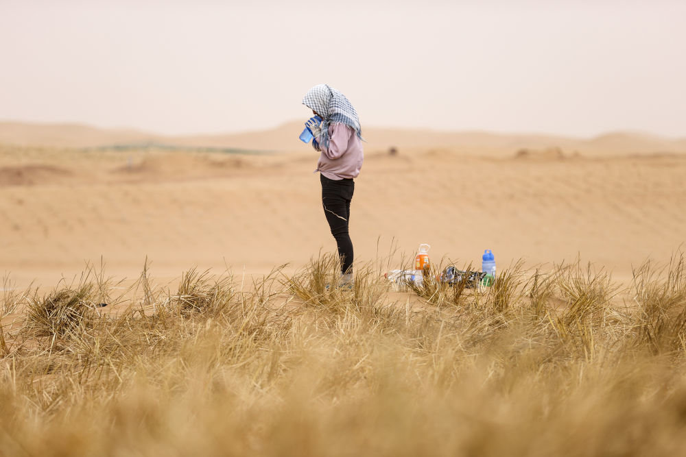 一名治沙工人在扎草方格间隙喝水（2020年8月27日摄）。 新华社记者 冯开华 摄