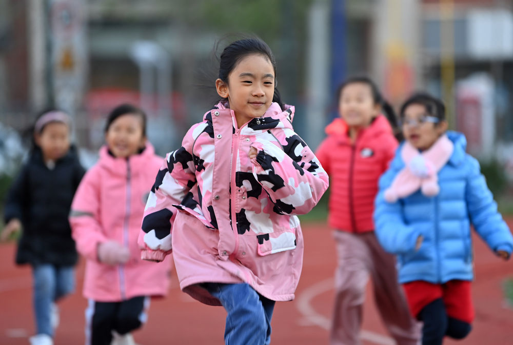 ↑在天津市河西区德贤小学，学生在课后素质拓展课上跑步锻炼（2021年11月11日摄）。