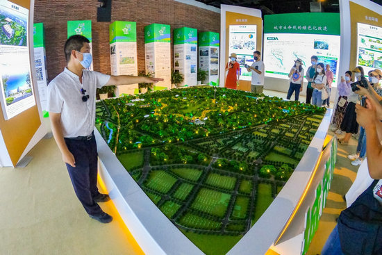 城市绿心森林公园工作人员为记者介绍园区情况/摄影 郑立文