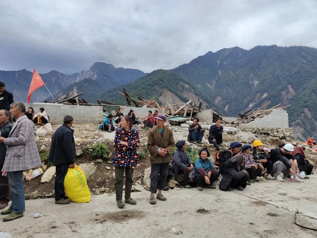 9月6日，四川泸定，湾东村村民在红花岗上等待撤离。肖丽/摄