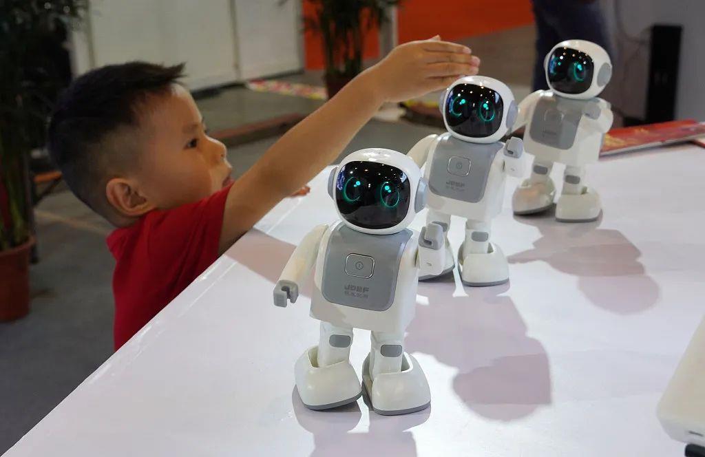 △2019年9月7日，首届中国-东盟人工智能峰会产品展在南宁国际会展中心拉开帷幕。一名儿童在5G体验区观看机器人跳舞。