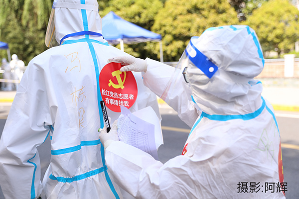 罗碧峰为社区党员志愿者贴标志.