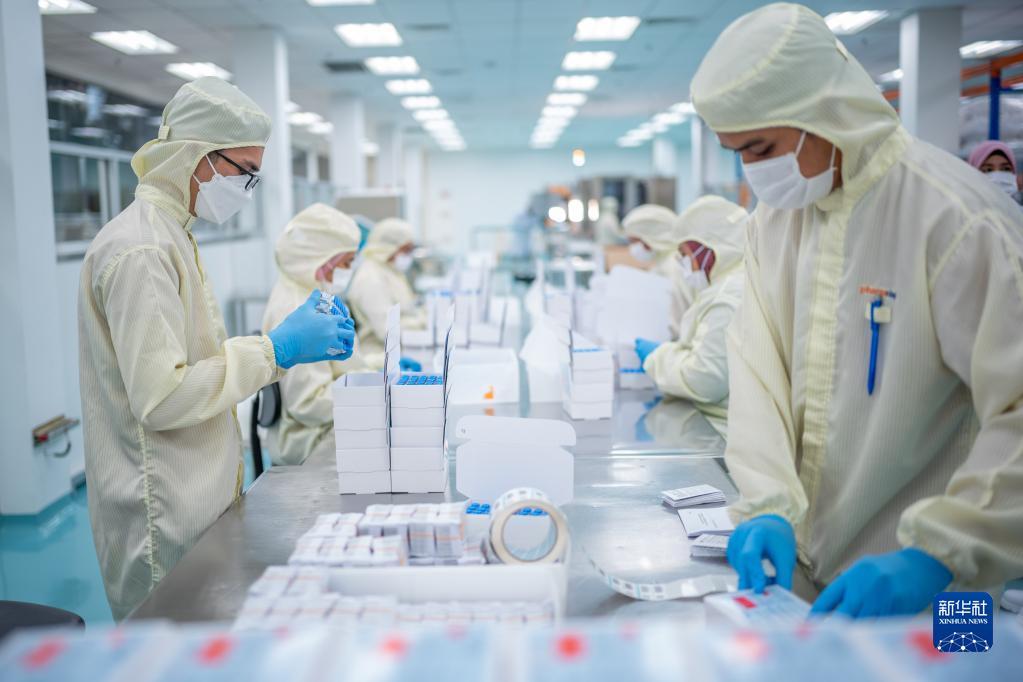 2021年10月5日，在马来西亚吉隆坡郊区的发马公司灌装工厂，工人包装本地灌装生产的中国科兴新冠疫苗。新华社记者朱炜摄
