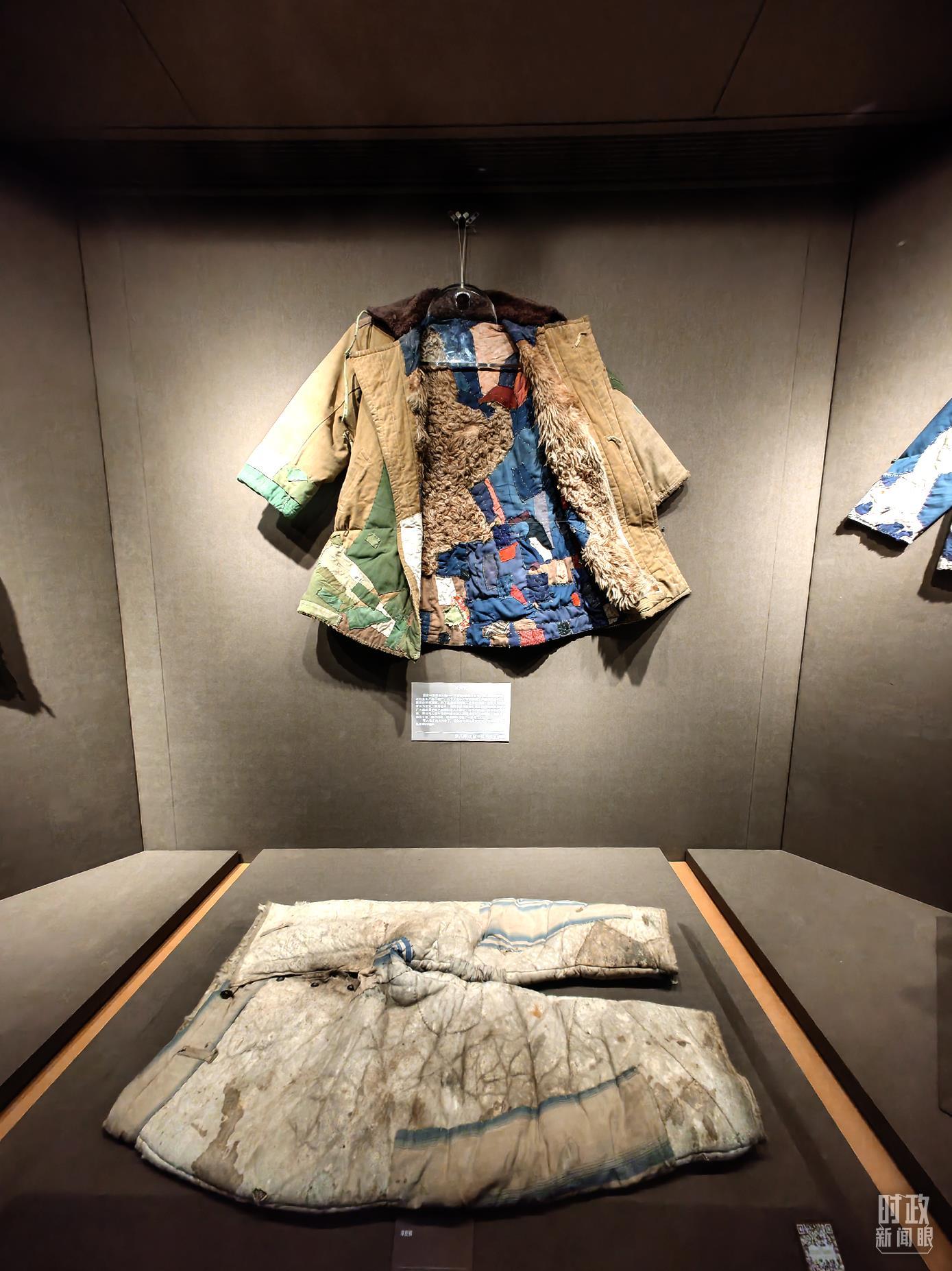 △博物馆内陈列着一件镇馆之宝——“百衲衣”,这件1950年配发的军大衣来自老军垦战士王德明,衣服上补满了大大小小各种颜色的补丁296块。(总台央视记者彭汉明拍摄)