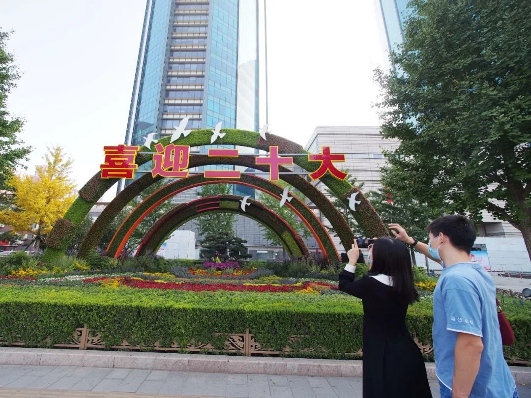 在北京双子座大厦前，市民拍摄“喜迎盛会”花坛。本报特约摄影 杜建坡