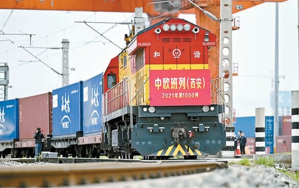 党的十八大以来,习近平总书记高瞻远瞩地提出构建人类命运共同体,是对马克思世界历史理论的继承和发展,成为了引领时代潮流和人类前进方向的鲜明旗帜。根据“十四五”规划和2035年远景目标纲要,我国依托超大规模市场优势,推动共建“一带一路”行稳致远,推动构建人类命运共同体。图为2021年4月13日,X9041次中欧班列(西安)从西安国际港站出发。这是2021年陕西开行的第1000列中欧班列。 李一博摄