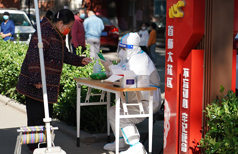 为尽快筛查出社会面隐匿病例，北京市从2022年5月13日开始，利用周末窗口期，连续三天在12个区开展三轮区域核酸筛查。图为5月13日，在北京市海淀区八里庄街道首师大社区的一处临时核酸检测采样点，工作人员登记市民信息。新华社记者 任超/摄