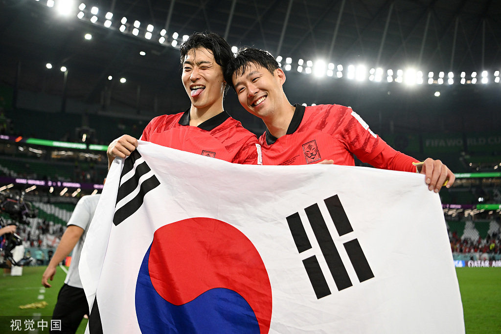 孙兴慜（右）和曹圭成手举韩国国旗。