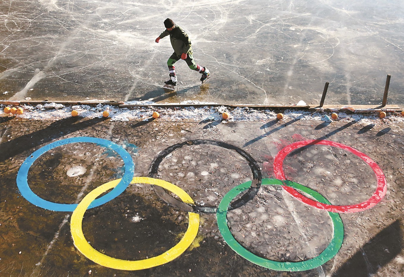 滑冰爱好者在沈阳一公园冰面上的“五环”标志旁滑冰健身。