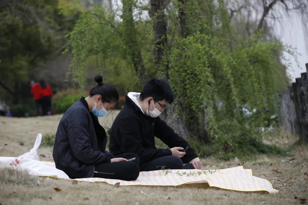 3月23日，上海市闵行区一小区内，两名年轻人正在户外晒太阳。解放日报社 李茂君/摄