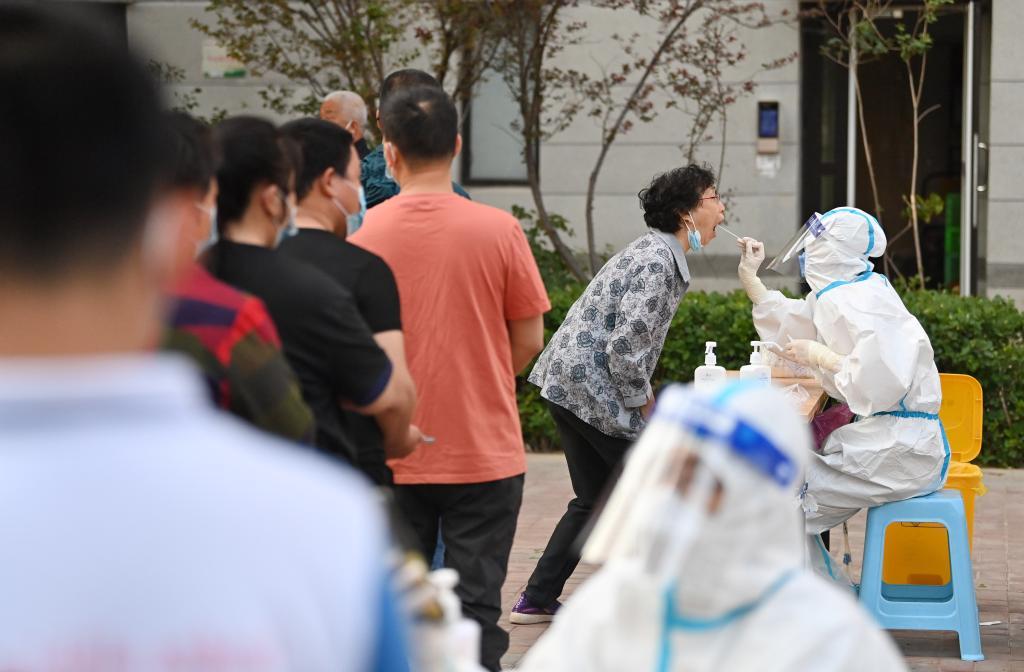 5月21日,在天津市西青区中北镇锦曦花苑社区,居民在排队进行核酸检测