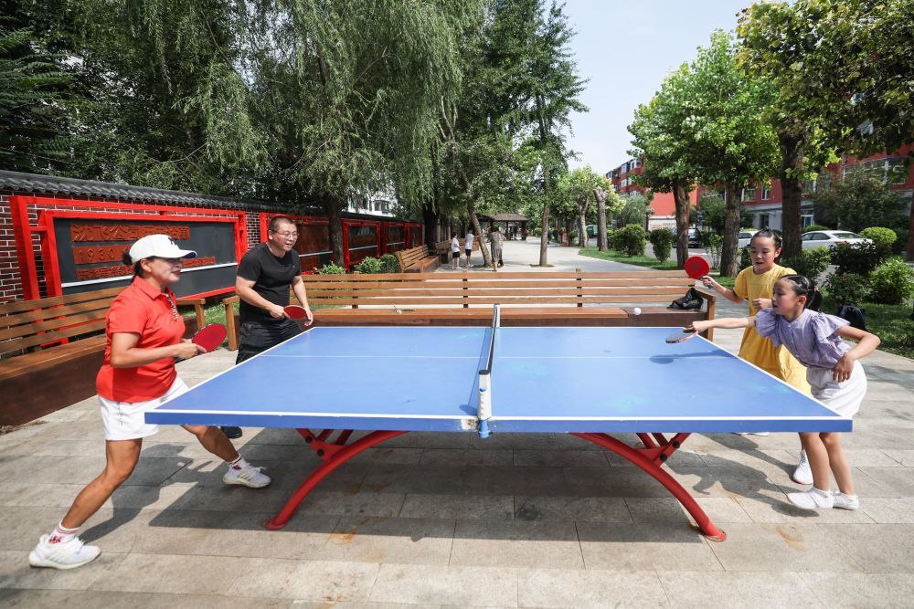 ↑8月18日，牡丹社区的居民在社区打乒乓球。