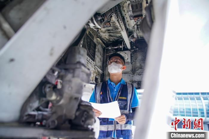 图为航线维护工程师对飞机进行检查。 陈冠言 摄