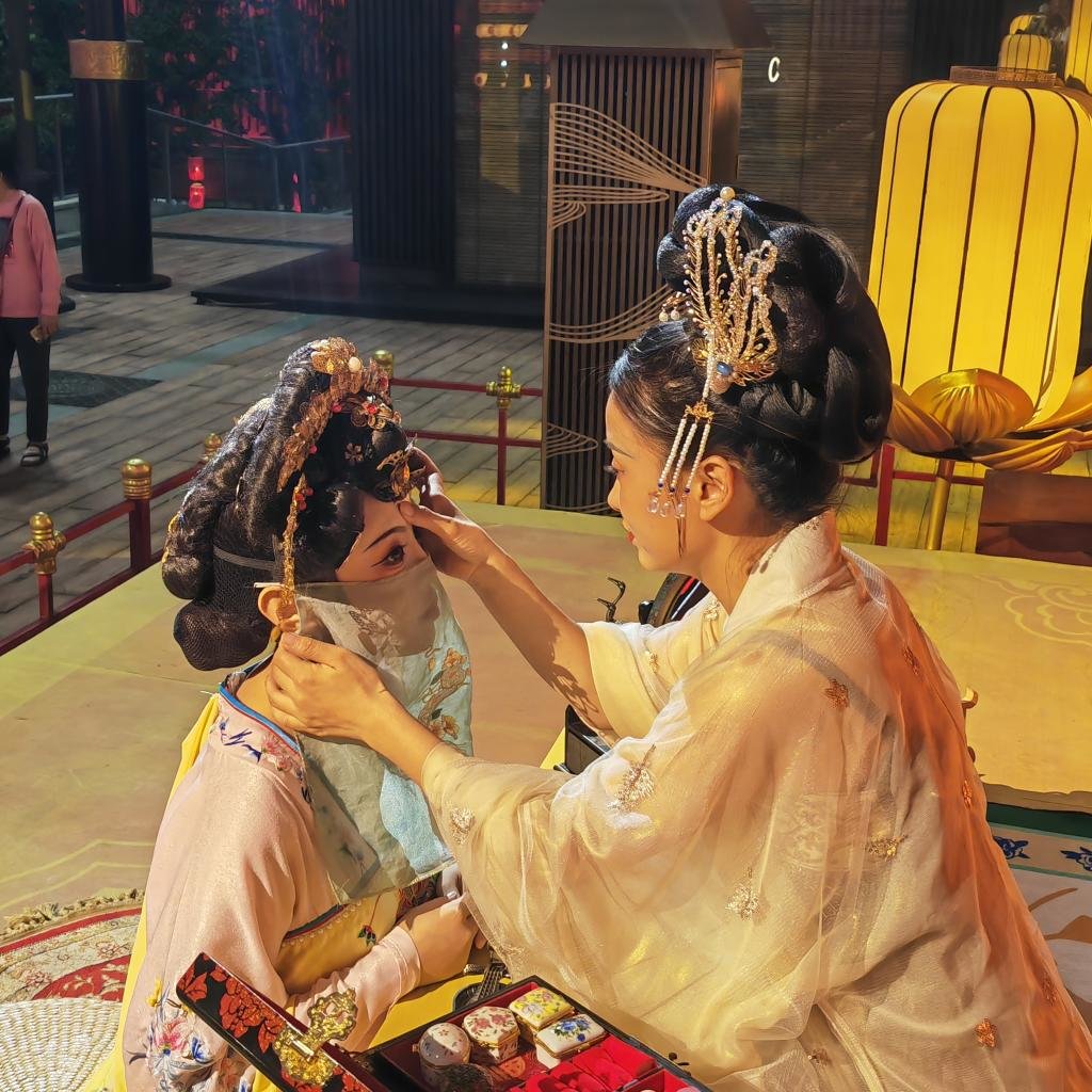 在西安大唐不夜城，古装演员正在向游客展示唐时“贴花钿”妆容。新华社记者 姜辰蓉 摄