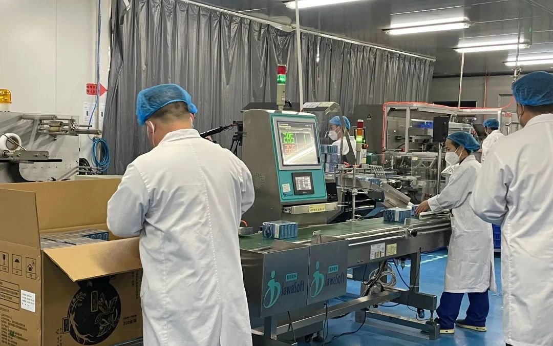 ▲12月11日下午，北京春风药业有限公司生产车间里，员工正逐一对药盒上的“溯源码”进行检验。新京报记者 熊丽欣 摄