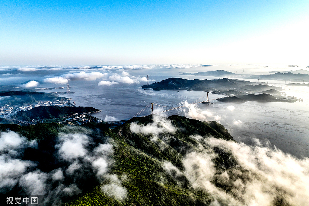 2022年5月6日，浙江省舟山市定海区金塘岛仙人山顶，晨雾弥漫，晨光照射云层，尽染海岛风光。