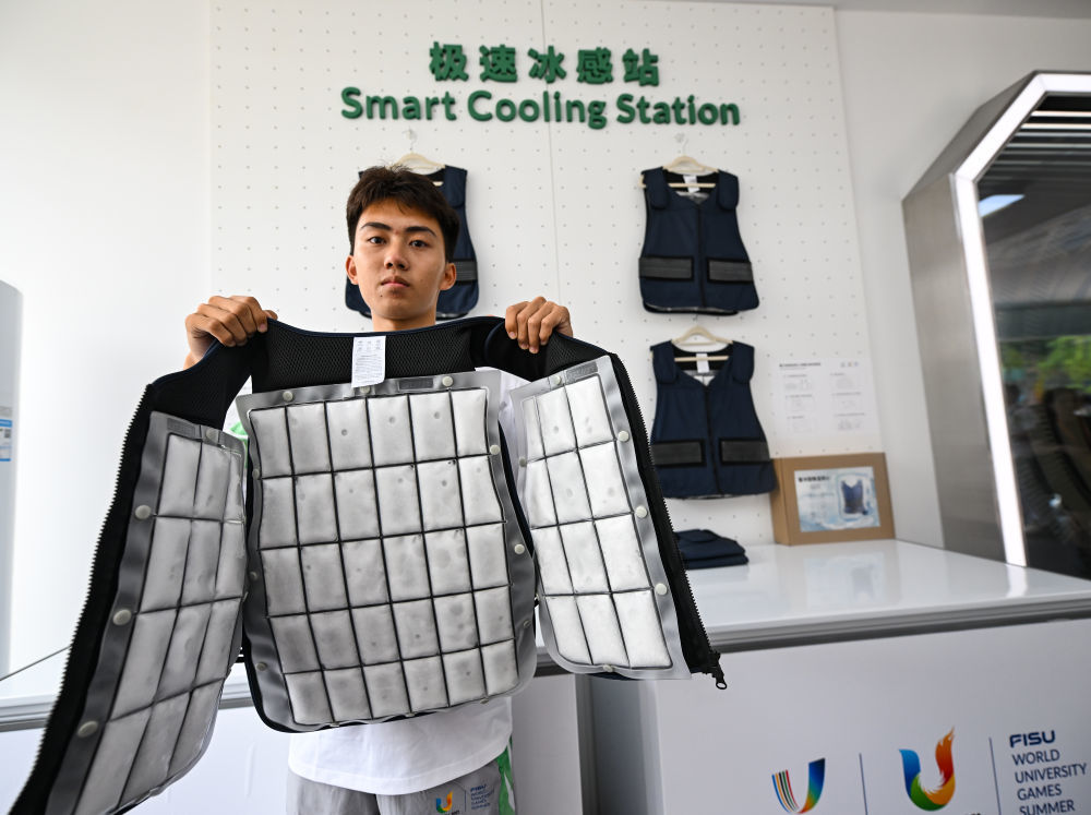 ↑7月15日，在大运村科技服务工作站，工作人员在展示降温冰背心。新华社记者 王曦 摄