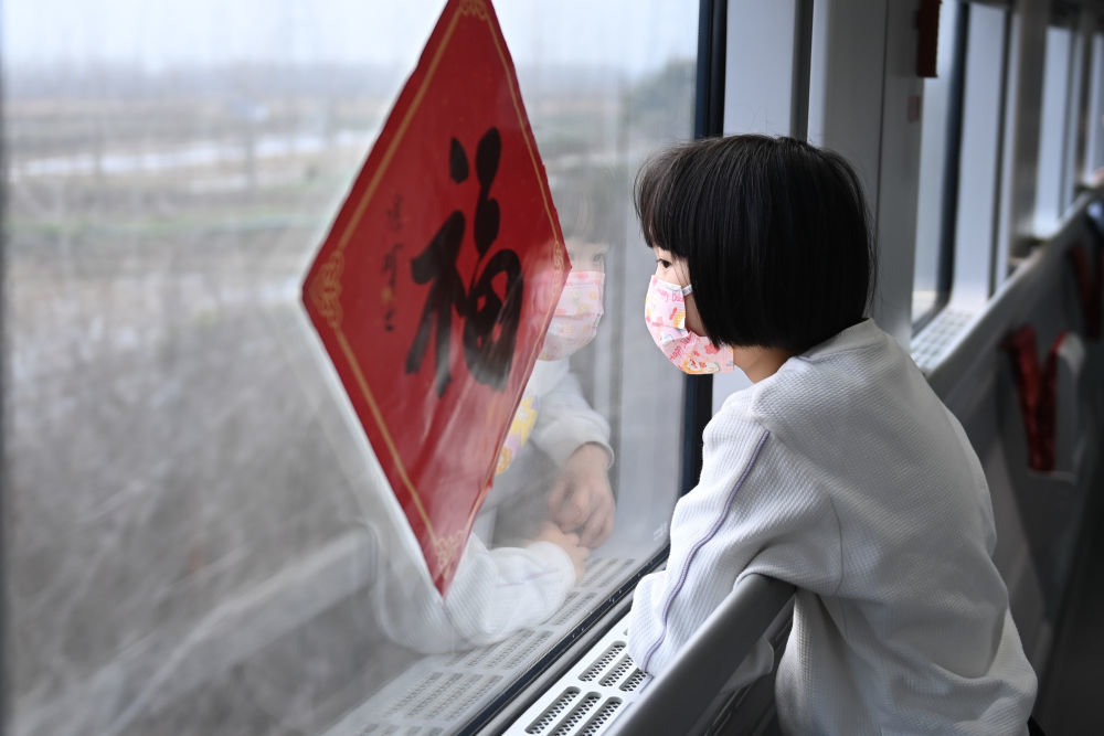 1月18日,准备回重庆外婆家过年的贝贝在列车窗边观看沿途的风景