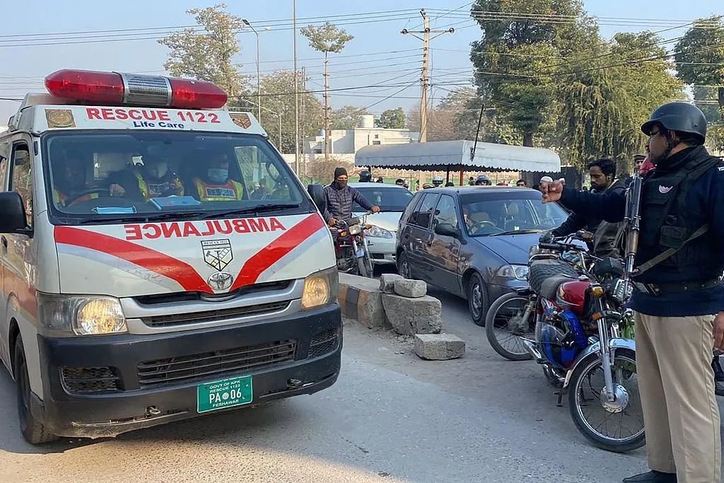 当地时间2023年1月31日，巴基斯坦白沙瓦，一名警察在警察总部内为救护车让路。图/视觉中国