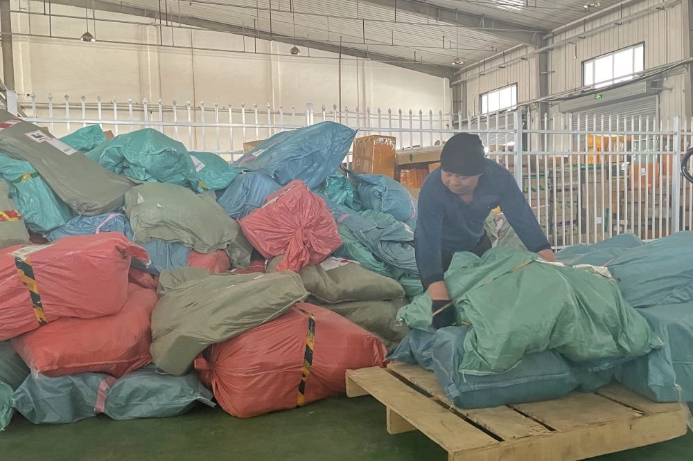 2023年3月21日,阿拉山口跨境电商分拣中心,工人正在分拣货品准备装车。新华社记者郝玉 摄