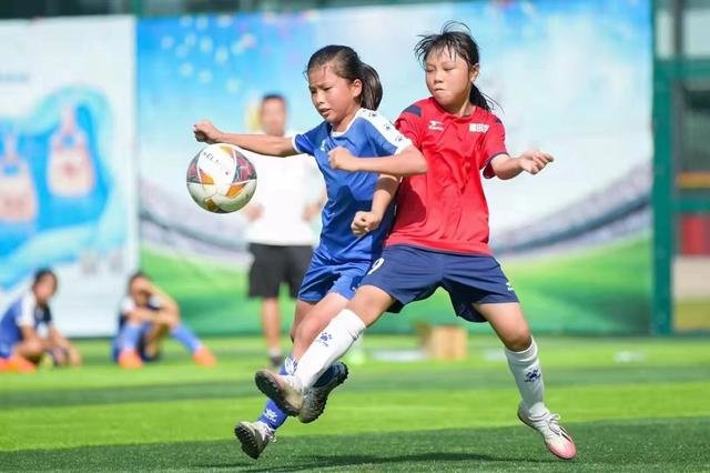 两名小女足队员在一场深圳市中小学生校园足球比赛中拼抢（2021年11月摄）。新华社发
