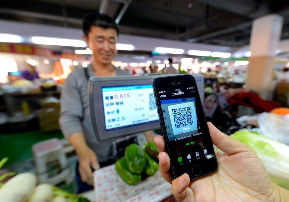 在河北省邯郸市一家便民市场，消费者在扫码支付购买蔬菜（2018年6月3日摄）。新华社记者 王晓 摄