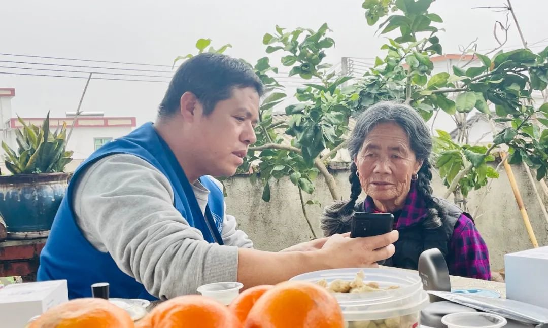 ▲潘华雄(左)教老人使用助听器