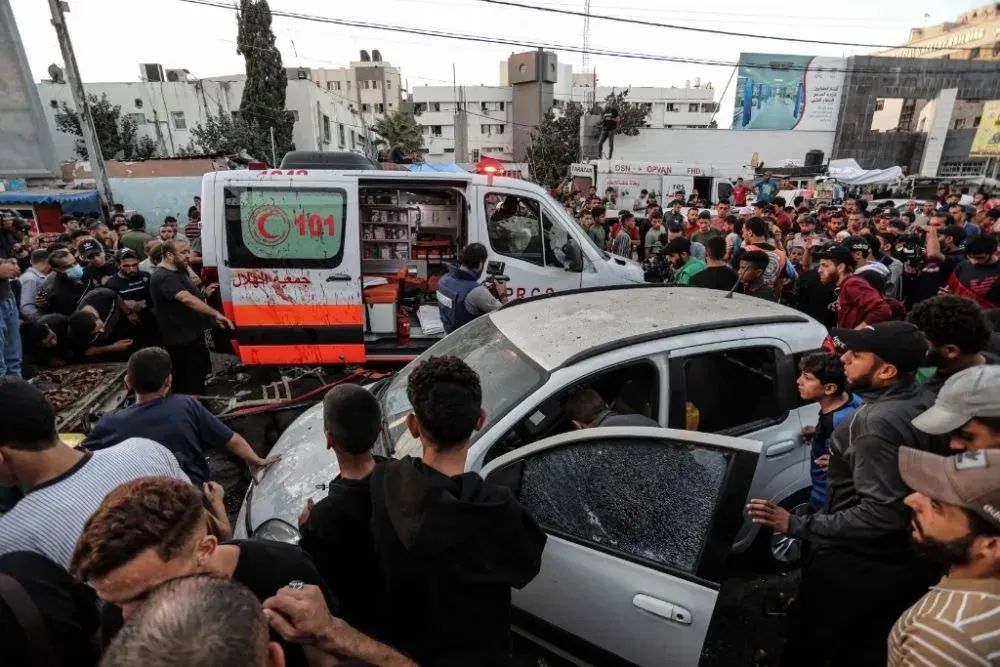 11月3日，在加沙城希法医院门口，人们查看被袭击的车辆。新华社发