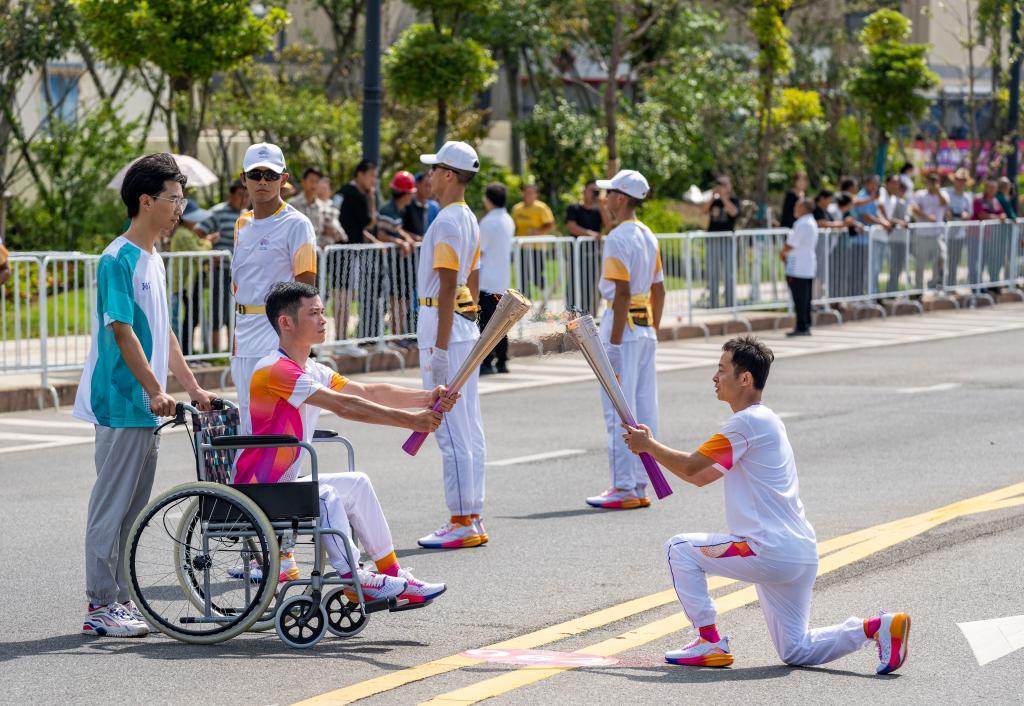9月13日，火炬手张海斌（左）和贺云飞在火炬传递中。新华社记者 孙非 摄
