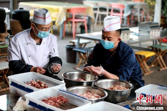 工作人员正在串肉串。 梁犇 摄