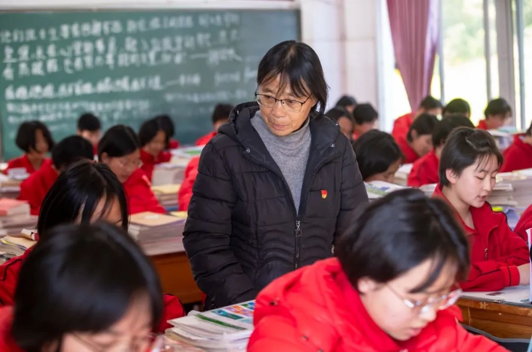 云南丽江华坪女子高级中学校长张桂梅(中)在教室里检查学生上课情况 图源:新华社
