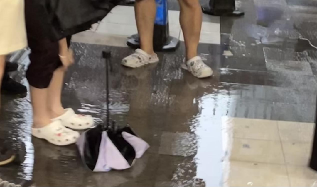 7月31日北京雨中地铁出口的洞洞鞋；摄影：李莹