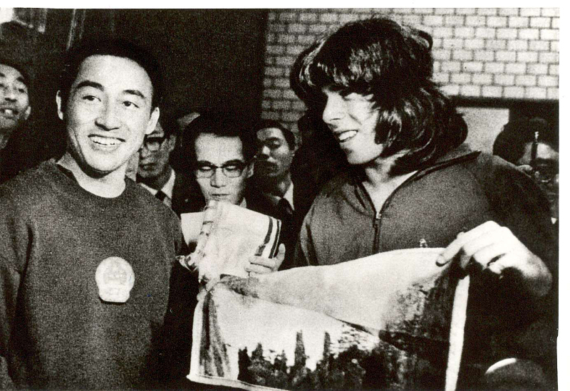 1971年4月，日本名古屋，第31届世界乒乓球锦标赛期间，中国乒乓球队的运动员庄则栋（左）将一块织锦工艺品赠送给美国乒乓球队的运动员格伦·科恩（右）。图源：视觉中国