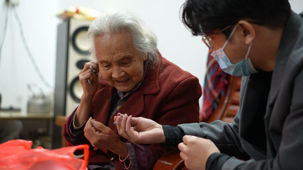 ▲助听器验配师帮助老人调试设备