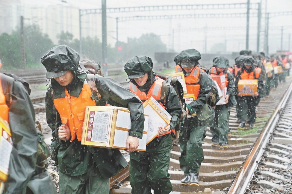 8月1日，武警战士携带物资冒着风雨向妙峰山镇水峪嘴村徒步行进，援救被困、受伤群众。 本报记者 王海欣摄