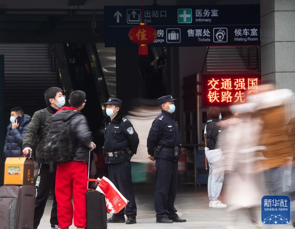 1月21日,民警王劲松(右)与同事刘小龙在湖北省宜昌东站出站口执勤。新华社记者肖艺九摄