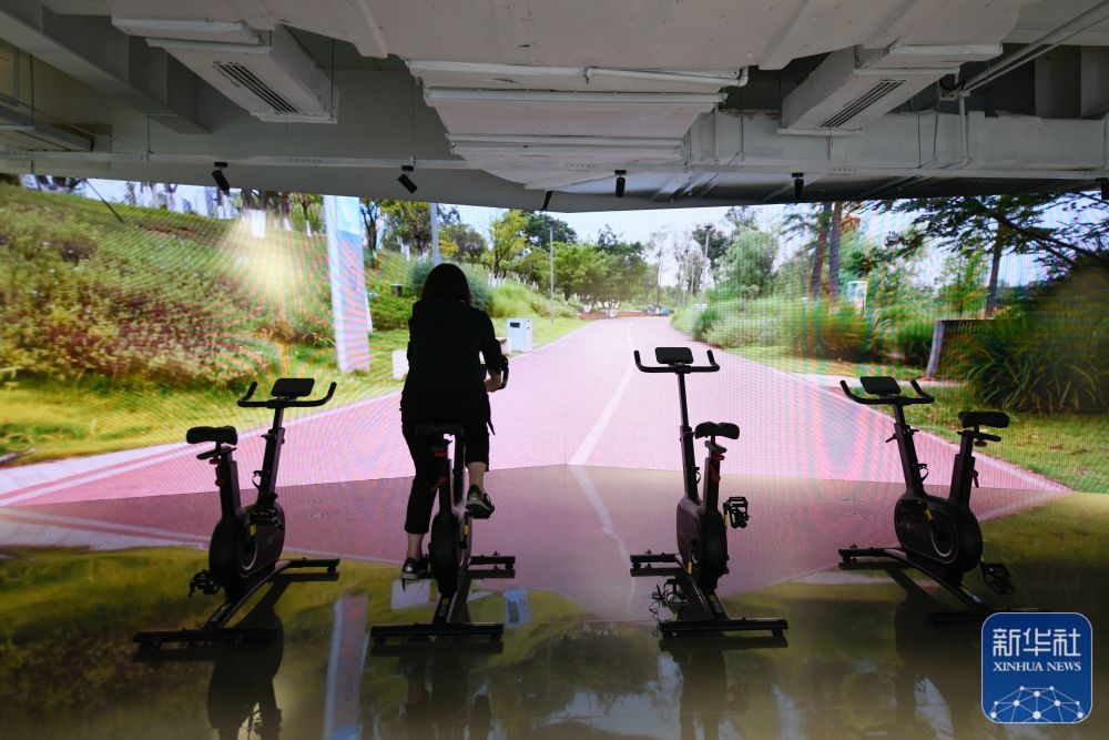 ↑7月14日,媒体工作人员在成都大运会主媒体中心休闲娱乐区内体验骑行。新华社记者 胥冰洁 摄