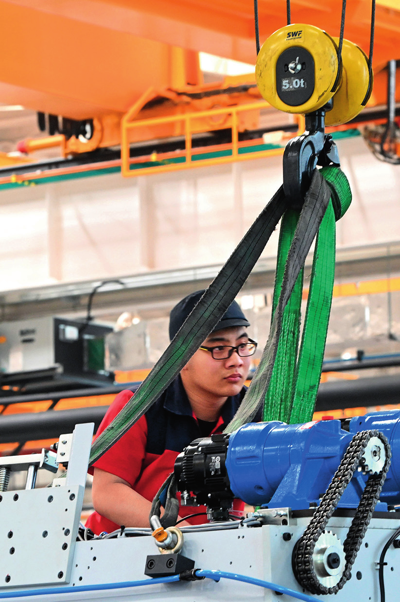 企业员工在天津长荣科技集团股份有限公司生产专区内工作 （2023 年 4 月 18 日摄） 李然摄 / 本刊