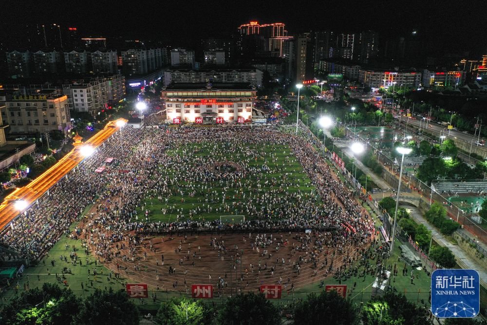 ↑6月10日，演员在贵州“村超”足球比赛后表演民族舞蹈“多耶”，现场观众一起上场狂欢（无人机照片）。 新华社记者 杨文斌 摄