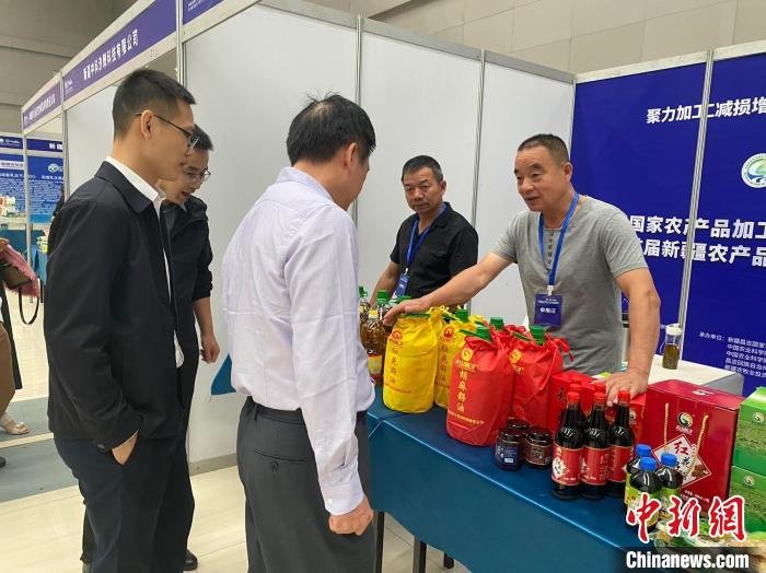 与会嘉宾与参展企业代表交流。 周璇 摄