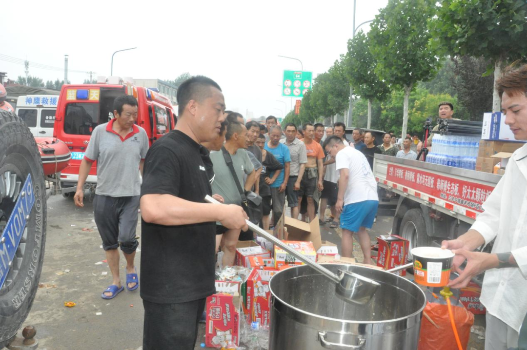 腾飞大街救援现场，一位志愿者为群众提供泡面 田国宝/摄
