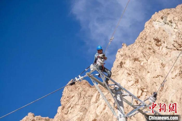 通电前，电力建设人员进行线路消缺工作。周广科 摄