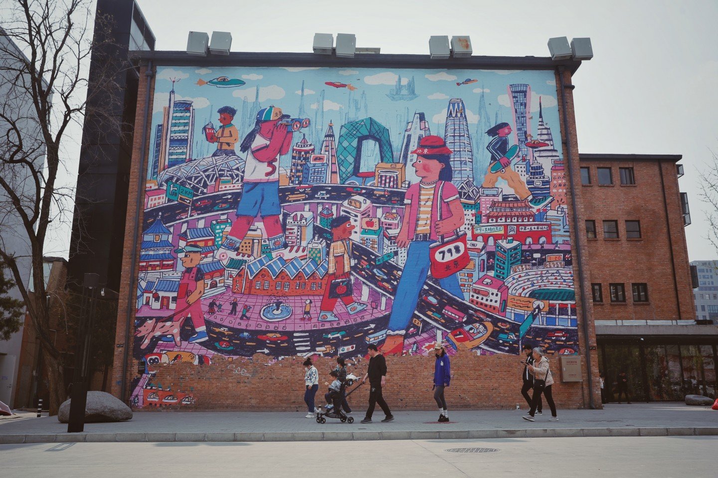 798艺术区，游客走过涂鸦墙。新京报记者 薛珺 摄