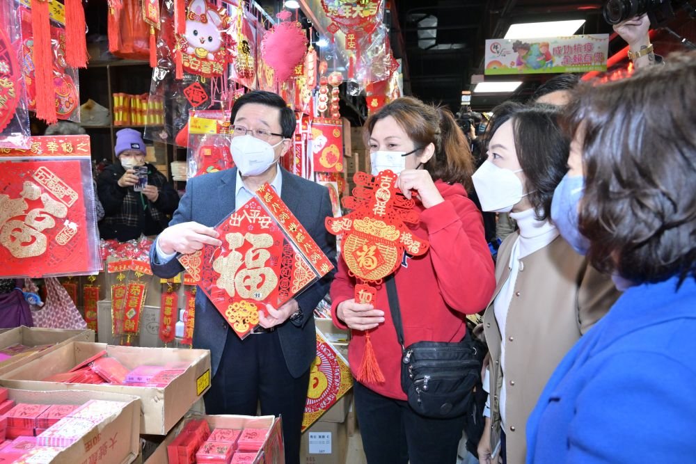1月20日，香港特区行政长官李家超和特区政府民政及青年事务局局长麦美娟、民政事务总署署长张赵凯渝与商贩倾谈，了解经营情况。新华社发（香港特区政府新闻处供图）